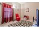 Cozy bedroom features a red accent chair and leopard print rug at 15977 W Latham St, Goodyear, AZ 85338