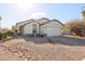 House with light-colored exterior and a well-maintained front yard at 15977 W Latham St, Goodyear, AZ 85338