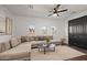 Bright living room featuring a large sectional sofa, modern ceiling fan and decorative rug at 2205 E Taurus Pl, Chandler, AZ 85249