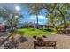Landscaped backyard featuring a grassy area, mature trees, and a bench at 2536 E Wood Pl, Chandler, AZ 85249