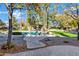 Spacious backyard with a sparkling pool, covered patio, and lush landscaping at 2536 E Wood Pl, Chandler, AZ 85249