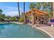 Relaxing pool area featuring a pergola with seating and a built-in fireplace at 2536 E Wood Pl, Chandler, AZ 85249
