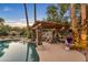 Serene poolside setting with a pergola, comfortable seating, and a fireplace at 2536 E Wood Pl, Chandler, AZ 85249