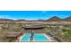 Resort style community pool with lounge chairs, sun umbrellas, and mountain views in the background at 32722 N 132Nd Ln, Peoria, AZ 85383