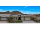 Beautiful single Gathering home featuring lush landscaping, neutral exterior, and a two car garage at 32722 N 132Nd Ln, Peoria, AZ 85383