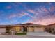 Beautiful home featuring desert landscaping, a three-car garage, and stone accents against a vivid sky at 32722 N 132Nd Ln, Peoria, AZ 85383