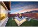 Backyard firepit with lounge seating, lush artificial grass and sunset views at 32722 N 132Nd Ln, Peoria, AZ 85383