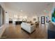 Open-concept living room flows into a modern kitchen, featuring hardwood floors and recessed lighting at 32722 N 132Nd Ln, Peoria, AZ 85383