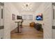 Modern office with adjustable desk, bright lighting, hardwood floors and wall-mounted television at 32722 N 132Nd Ln, Peoria, AZ 85383