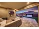 Covered patio with stone flooring, fireplace, TV and outdoor dining set with mountain views at 32722 N 132Nd Ln, Peoria, AZ 85383