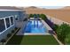 Backyard pool boasts with built in water feature, in-pool seating, landscaping and modern patio at 32722 N 132Nd Ln, Peoria, AZ 85383