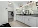 Spa-like bathroom with double sinks, large mirror, and walk-in shower at 40108 W Crane Dr, Maricopa, AZ 85138