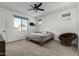 Spacious bedroom with ceiling fan and large window at 40108 W Crane Dr, Maricopa, AZ 85138