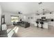 Open floor plan with gray sectional sofa, kitchen island, and backyard access at 40108 W Crane Dr, Maricopa, AZ 85138