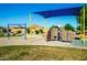 Playground featuring swings, climbing wall, and shade structure at 40108 W Crane Dr, Maricopa, AZ 85138