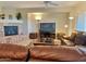 Living room with a cozy stone fireplace and comfortable leather seating at 42127 N Celebration Way, Anthem, AZ 85086
