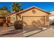 Tan one-story house with two-car garage and desert landscaping at 588 N Amber Ct, Chandler, AZ 85225