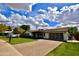 A well-maintained single-story house with a brick driveway, lush lawn, and modern garage door at 615 E Winter Dr, Phoenix, AZ 85020