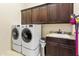 Laundry room with washer, dryer, and cabinets at 8433 E Leonora St, Mesa, AZ 85207