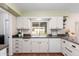 Kitchen with white cabinets, a large window and dark countertops at 10012 W Sandstone Dr, Sun City, AZ 85351