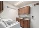 Bright laundry room with washer, dryer, cabinets, and sink at 10035 E Diamond Dr, Sun Lakes, AZ 85248