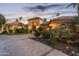 Elegant home exterior with arched entry and landscaping at dusk at 10489 N 99Th St, Scottsdale, AZ 85258