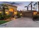 Home exterior with double garage and arched entryway at dusk at 10489 N 99Th St, Scottsdale, AZ 85258