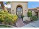 Elegant entryway with arched doorway, brick pathway, and lush landscaping at 10489 N 99Th St, Scottsdale, AZ 85258