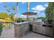 Outdoor kitchen with built-in grill, bar, and seating area at 10489 N 99Th St, Scottsdale, AZ 85258