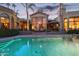 Expansive pool and back view of house at dusk with large windows and patio at 10489 N 99Th St, Scottsdale, AZ 85258