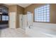 Bathroom with soaking tub, shower, and large window at 1060 W Silver Creek Rd, Gilbert, AZ 85233