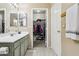 Bathroom with double vanity, large mirror, and walk-in closet at 11025 W Lane Ave, Glendale, AZ 85307