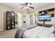 Bedroom with large TV, ceiling fan, and built-in shelving at 11025 W Lane Ave, Glendale, AZ 85307