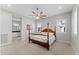 Bedroom with wood post bed, ceiling fan and bathroom access at 122 E Orange Blossom Path, Queen Creek, AZ 85140