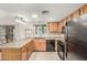 Kitchen features L-shaped counters, oak cabinets, and black appliances at 12510 W Brandywine Dr, Sun City West, AZ 85375