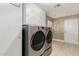 Laundry room with modern washer and dryer, cabinets, and exterior access at 12510 W Brandywine Dr, Sun City West, AZ 85375