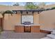 Outdoor kitchen with built in grill and tile accents at 15418 N Castillo Dr, Fountain Hills, AZ 85268