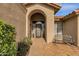 Inviting house entrance with stone pathway, arched entryway, decorative door, and wrought iron bench at 160 W La Vieve Ln, Tempe, AZ 85284