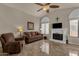 Living room with fireplace, brown couches, and a ceiling fan at 160 W La Vieve Ln, Tempe, AZ 85284