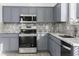 Modern kitchen with gray cabinets, granite counters, and stainless steel appliances at 16508 N 71St Ave, Peoria, AZ 85382