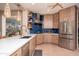 Modern kitchen with wood cabinets, white countertops, and blue tile backsplash at 19941 N Summer Dream Dr, Surprise, AZ 85374