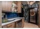 Elegant wet bar with granite countertop, glass shelving, and stylish backsplash at 19941 N Summer Dream Dr, Surprise, AZ 85374