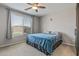 Bedroom with a ceiling fan, large window, and blue blanket on the bed at 20138 W Madison St, Buckeye, AZ 85326