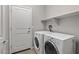 Laundry room with washer, dryer, and storage shelves at 20138 W Madison St, Buckeye, AZ 85326