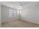 Bright bedroom with carpeted floor, window blinds, and ceiling fan at 2028 N 77Th Ln, Phoenix, AZ 85035