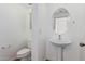 Small bathroom with pedestal sink, toilet and oval mirror at 20475 N Herbert Ave, Maricopa, AZ 85138