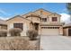 Two-story house with tan exterior, attached garage, and landscaping at 20475 N Herbert Ave, Maricopa, AZ 85138