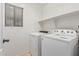 Bright laundry room with washer, dryer, and shelving at 20475 N Herbert Ave, Maricopa, AZ 85138