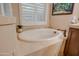 Relaxing bathroom featuring a large soaking tub and neutral tile at 21556 S 215Th Pl, Queen Creek, AZ 85142