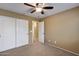 Bedroom with double doors to closet, carpeted floor, and ceiling fan at 24710 N 27Th Pl, Phoenix, AZ 85024